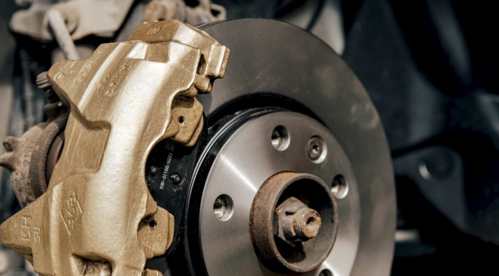 Close-up image of gold painted brake caliper on brake disc.